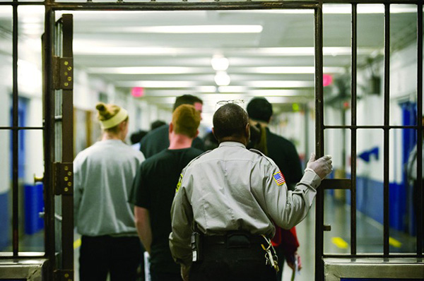 guard following people walking through door at jail