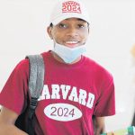 graduate wearing Harvard shirt