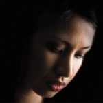 woman looking down in dark