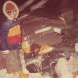two children and an adult playing in snow