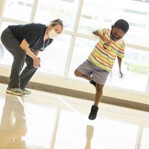 Physical therapist and young male student dancing