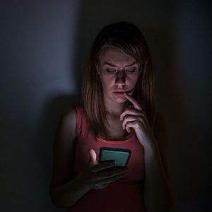 woman looking at phone in the dark