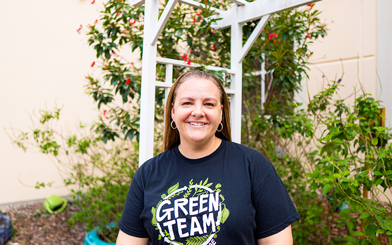 Amanda Ferguson smiles in front of a garden.