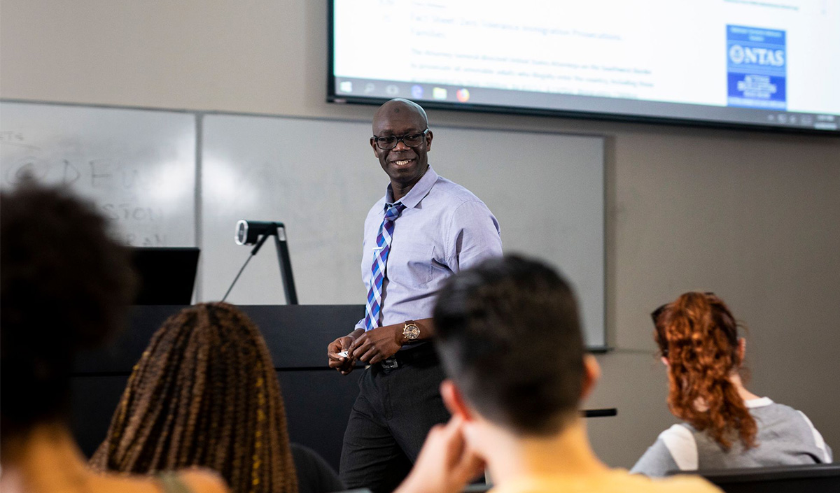 Professor Abdul-Akeem Sadiq speaks to students in a classroom.