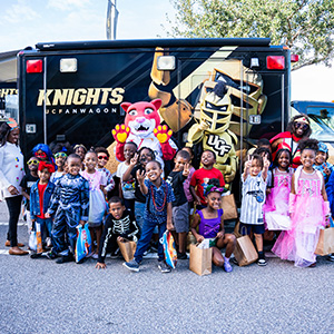 OCPS ACE students pose with the UCF Fan Wagon and Knightro during the Book Character Parade