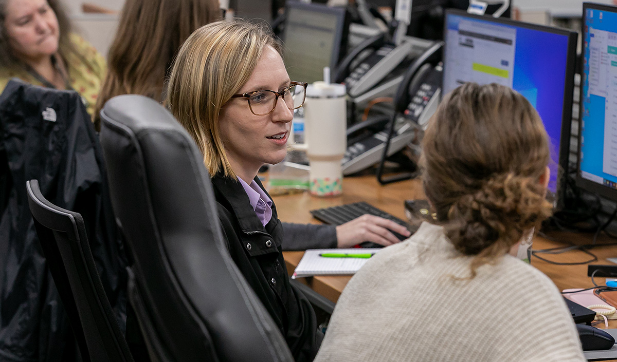 Hillarie Burgess sits at a chair in front of a computer at the Lake County Emergency Operation Center during Hurricane Idalia.