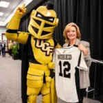 Lisa Nored holding custom jersey with UCF mascot, Knightro