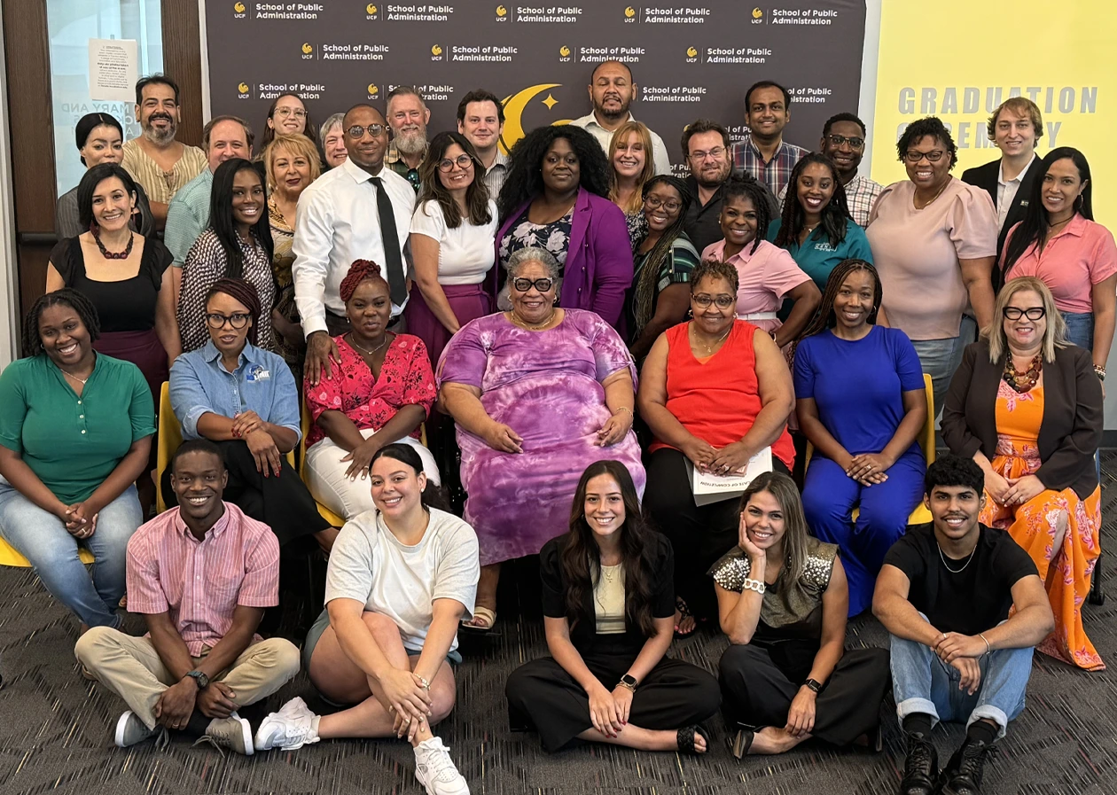 A group of professionals representing Orange County nonprofits pose together in a classroom at UCF Downtown following their graduation ceremony for completion of a capacity-building seminar series.