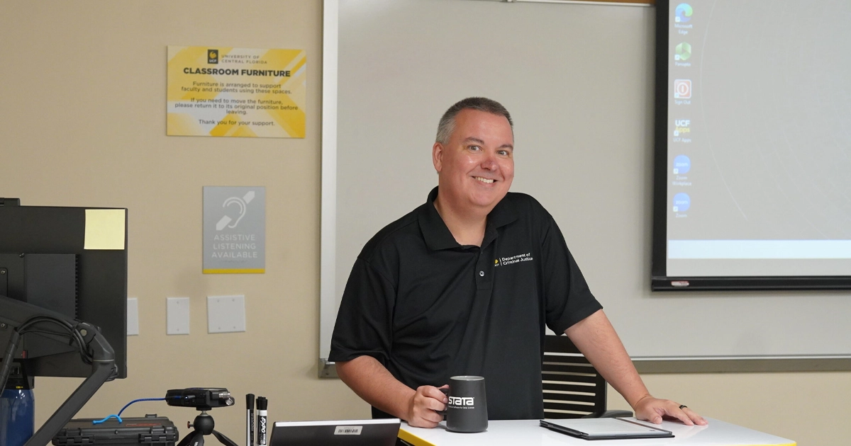 Matt Nobles in classroom holding a cup of coffee