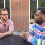 Two men sitting at a table having a discussion