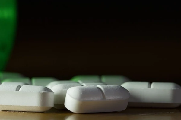 Bottle with pills spilling out on table