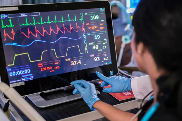 Hands wearing surgical gloves on laptop
