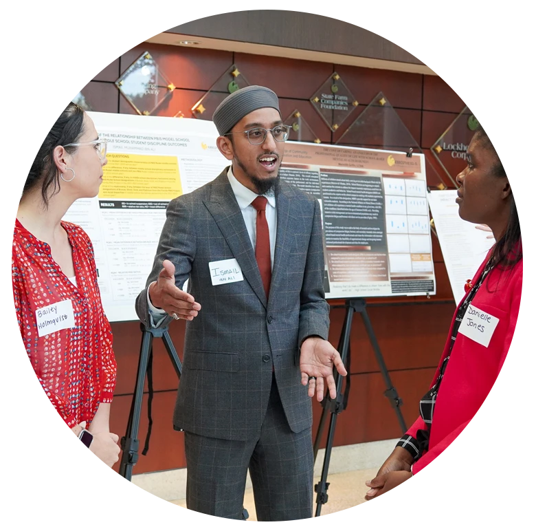Three students conversing at showcase