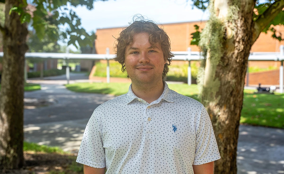 Nathan Kehoe standing outside in front of a tree