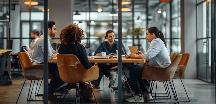 Group of people seated around a table in a meeting room