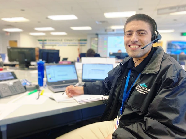 Man smiling at desk wearing headset