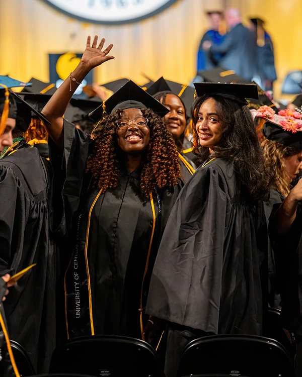 UCF graduates smiling in cap and gown
