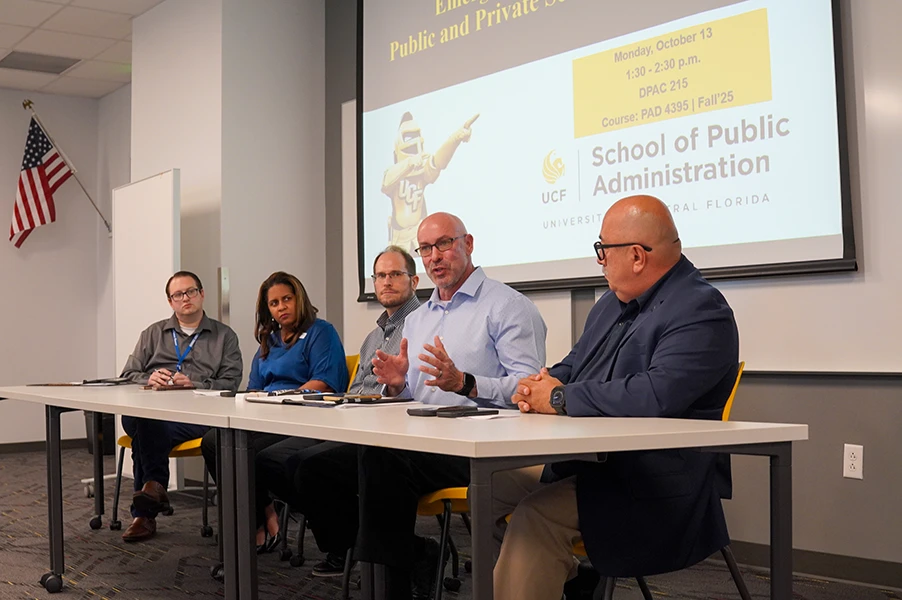 Panel of people in front of presentation screen