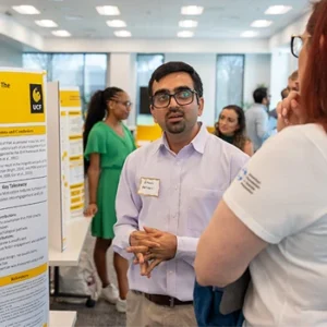 Bikash Adhikari speaking with woman at research conference