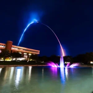UCF Reflection Pod lit by arch of lights at nighttime