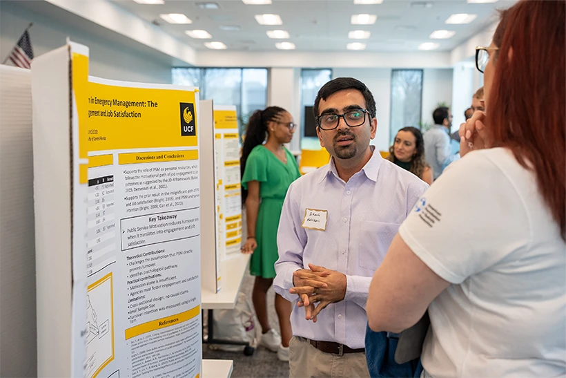 Bikash Adhikari speaking with woman at research conference