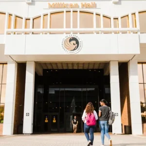 Two students walking in front of UCF Millican Hall building