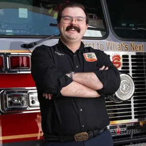 Josh Holder smiling in front of a fire engine