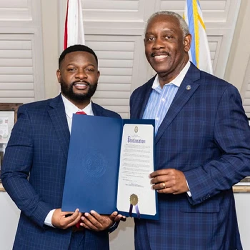 Britt Johnson accepting a proclamation from Mayor Jerry Deming