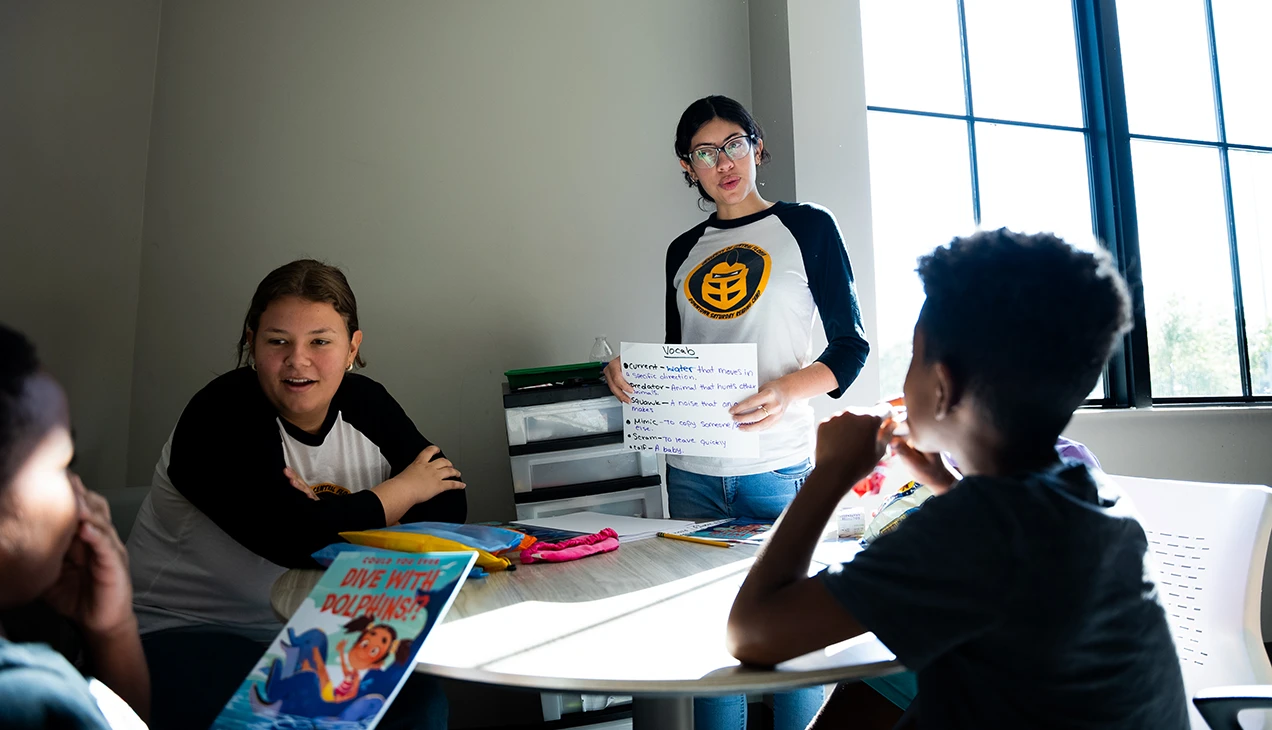 Two UCF teacher education students working with two children on vocabulary and reading
