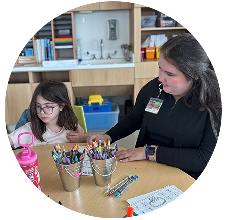 Natalie Ferguson working with elementary student in classroom